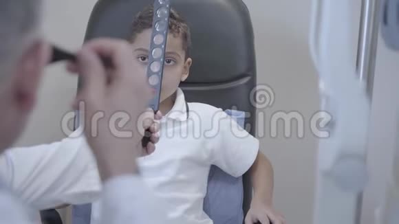 英俊的非裔美国人坐在医生的椅子上的肖像专业眼科医生检查视频的预览图
