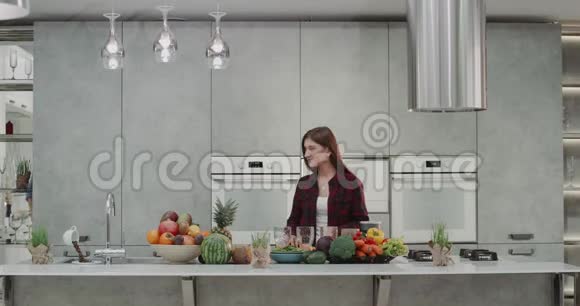 一对有魅力的年轻夫妇在现代厨房里一起做奶昔在客人面前女士准备视频的预览图