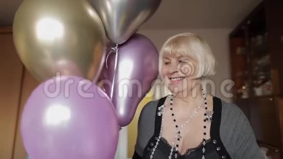 可爱的奶奶庆祝她的生日手里拿着五颜六色的气球视频的预览图