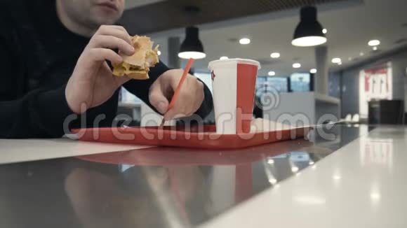 男士在快餐店吃汉堡或芝士汉堡喝汽水视频的预览图