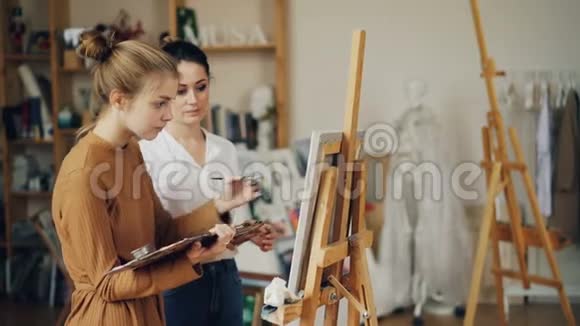 可爱的少女在工作室的艺术学校向有经验的老师学习绘画里面有艺术品和木头视频的预览图