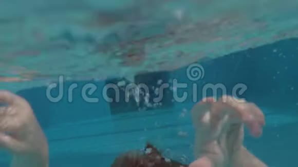 一个男孩在开放的游泳池里潜水的缓慢动作视频的预览图
