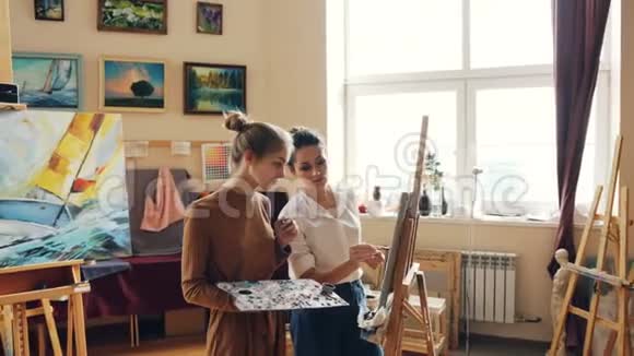 漂亮的女孩正在学习绘画有经验的女老师熟练的画家上课人们正在工作视频的预览图