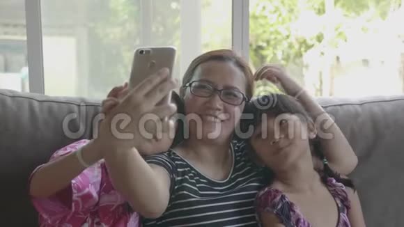 亚洲家庭携带智能手机在客厅视频的预览图
