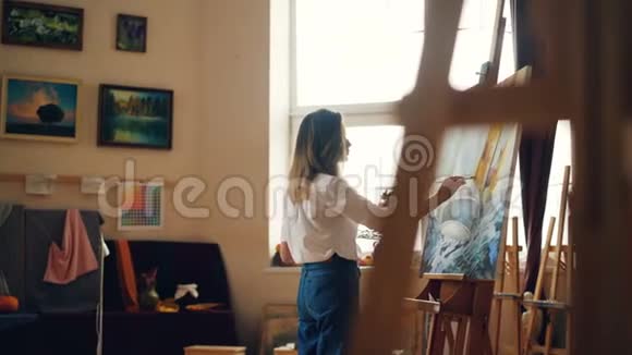 职业画家年轻的女士正在用丙烯酸颜料描绘海洋景观船和海浪视频的预览图