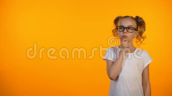 青春期前女孩在橙色背景下孤立思考计划教育视频的预览图