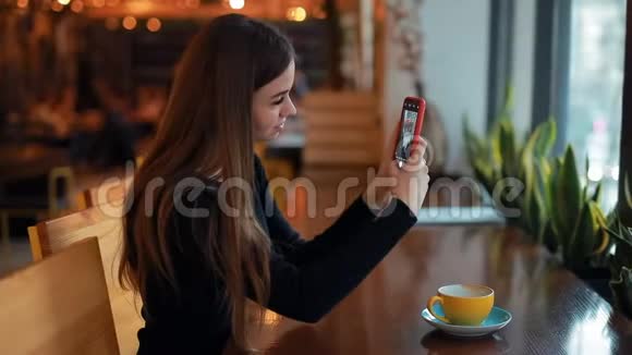 女博主在咖啡馆里为她的社交账户拍摄了一杯咖啡视频的预览图