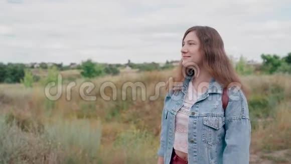 年轻女子在大自然的背景下眺望远方可爱的微笑女性站在户外视频的预览图