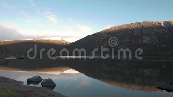 一个人一个旅行者在山上迎接日落他沿着湖岸散步欣赏倒影视频的预览图
