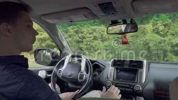 一对年轻男女坐在车里一对夫妇坐着汽车旅行视频的预览图