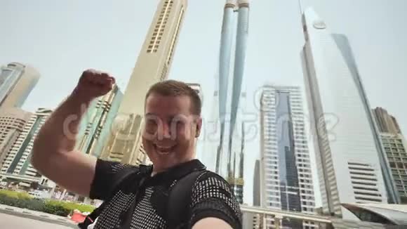 在迪拜摩天大楼的背景下快乐人获胜视频的预览图