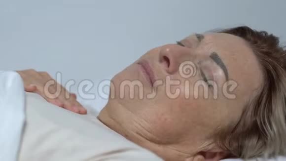 躺在床上发烧的老太太护士把湿毛巾贴在额头上视频的预览图