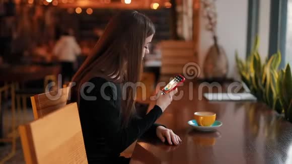 女博主在咖啡馆里为她的社交账户拍摄了一杯咖啡视频的预览图