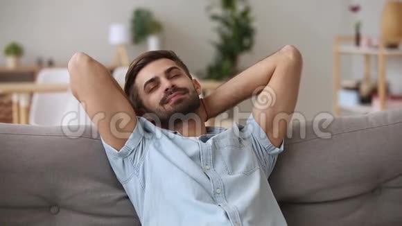平静快乐的年轻人在舒适的沙发上休息视频的预览图