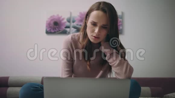 严肃的女人在笔记本电脑上搜索在线约会家庭在线教育视频的预览图