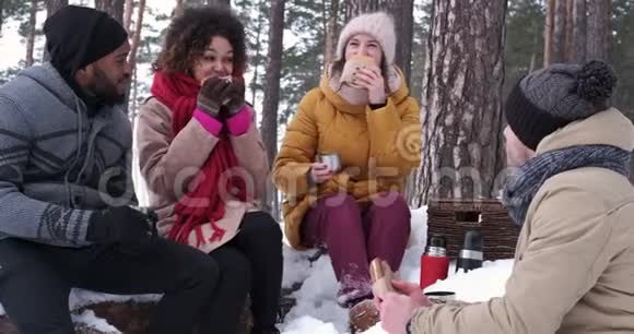快乐的年轻人在雪林野餐视频的预览图