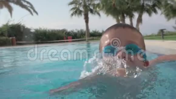 一个快乐的男孩在一个开放的游泳池里嬉戏视频的预览图
