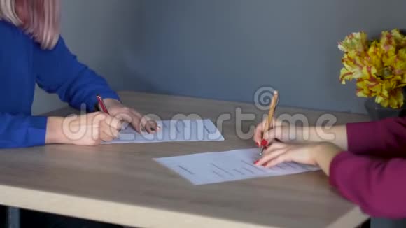 两个女商人签署合同时的手两个女人在办公室握手视频的预览图
