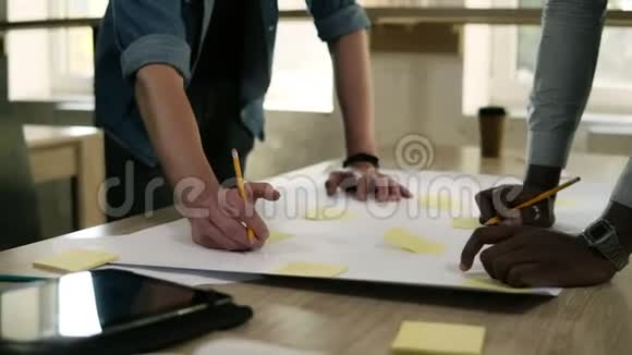 两个商人指着桌子桌子上有黄色的文件和商务会议上的铅笔他们是视频的预览图