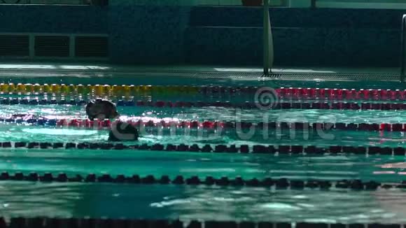 泳池中的游泳者轮廓模糊有蓝色的水和游泳轨迹的分隔视频的预览图