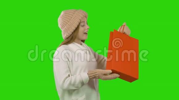 一个穿着冬装的红色长发的年轻女孩手里拿着礼物真诚地微笑着感到惊讶视频的预览图