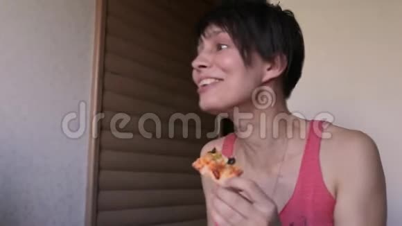 年轻聪明的女孩子一个男孩子理发坐在厨房里急切地吃披萨视频的预览图