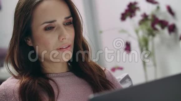 女人在笔记本电脑屏幕上读好消息家庭教育在线视频的预览图