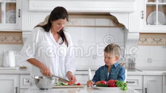 敏捷微笑的孩子在妈妈做饭的时候偷东西或吃一片食物视频的预览图