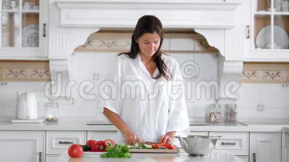 快乐的素食妇女用餐刀和餐板烹饪维生素夏季沙拉视频的预览图