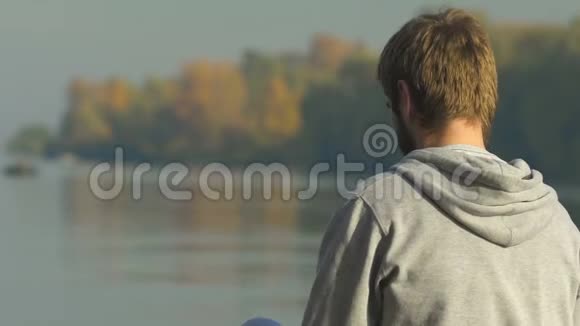 坐在河岸边看水的人在想他的未来计划视频的预览图