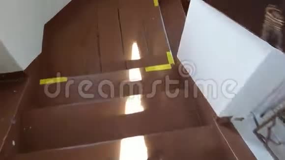 在方形电梯井周围围成一个圆圈沿着棕色的木制台阶往下走视频的预览图