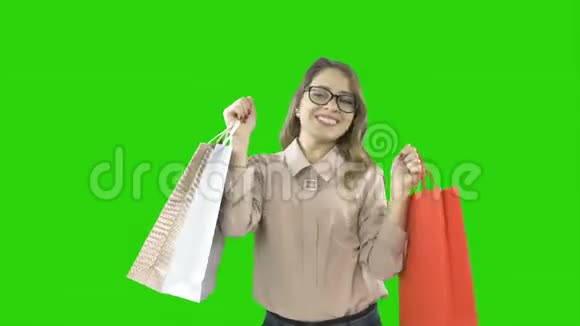 身着优雅的年轻女子戴着眼镜双手捧着购物袋热情地微笑着视频的预览图