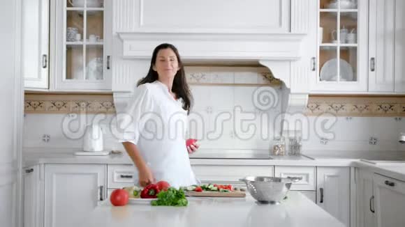 活泼的年轻微笑的女人在家中做饭享受乐趣跳舞老式厨房视频的预览图