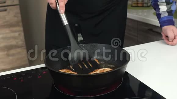 一个人用煮沸的油在平底锅中为汉堡包特写薯条或小切片那个粗人把一块块肉视频的预览图