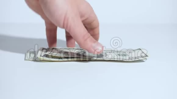 一个人手从桌子上拿走美元白色背景特写视频的预览图