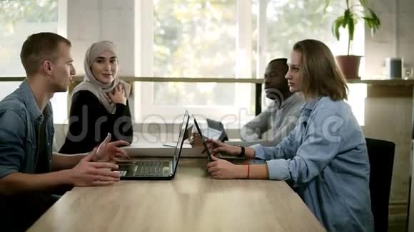 穆斯林妇女非洲男子和两名高加索人组成的四个混合种族和文化青年小组举行了会议视频的预览图