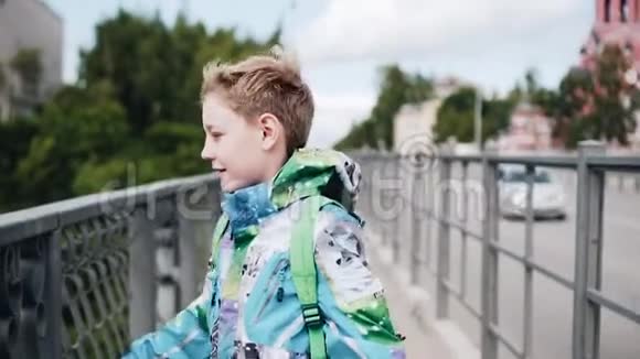 那个男孩站在桥上风在他的背上吹着头发在风中飘扬拍得不错视频的预览图