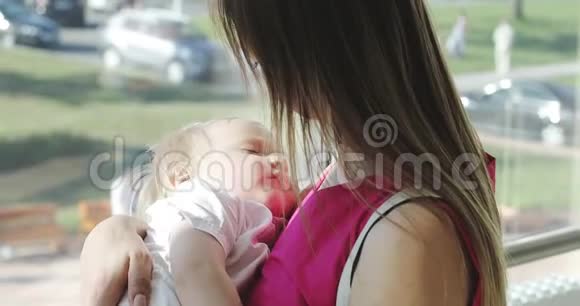一个年轻的女人怀里抱着一个熟睡的儿子视频的预览图
