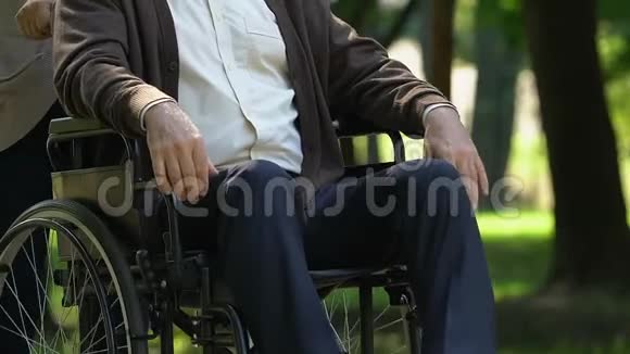 年长的女人对坐在轮椅上的老人充满温柔关怀视频的预览图