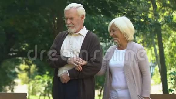 一对老夫妇在夏季公园拥抱和散步一起享受消遣视频的预览图