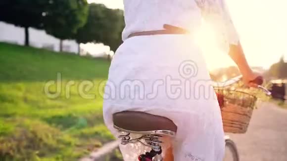 日落时骑自行车的年轻美女视频的预览图