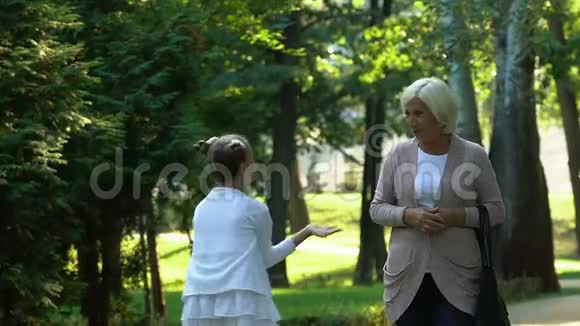 小女孩和奶奶一起散步讲述她在学校生活中的故事相信视频的预览图