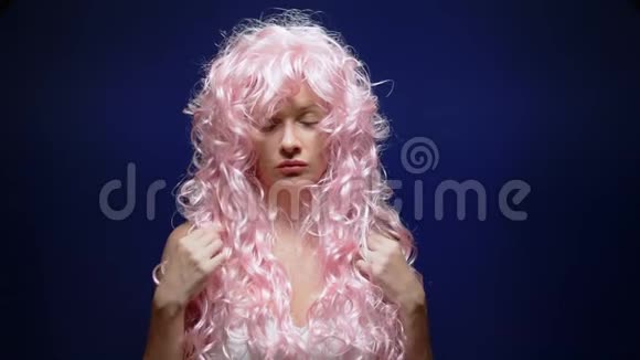 美丽可爱的女孩黑色背景上有一头粉红色的卷发视频的预览图