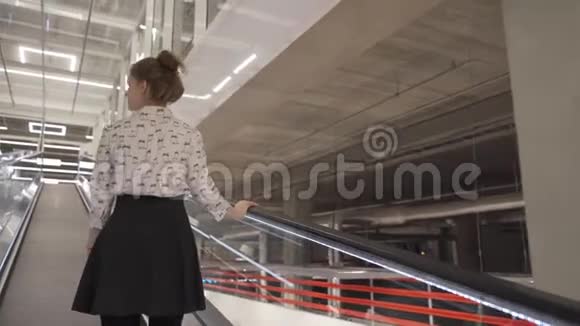 年轻的美女站在自动扶梯上视频的预览图