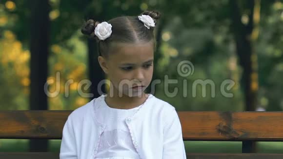 孤独的女孩坐在公园的长凳上在学校里受到欺凌和虐待视频的预览图