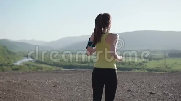 年轻女子健身跑步者在顶部快乐和庆祝成功镜头跟着年轻女子的田径比赛视频的预览图