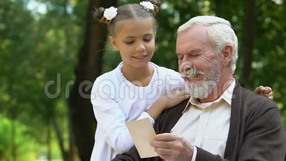 祖父给孙女看照片讲有趣的故事视频的预览图