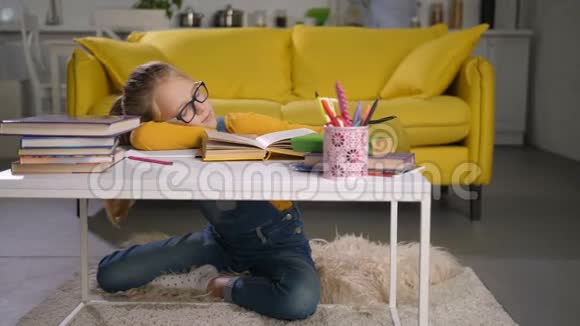 精疲力竭的女学生睡在家里的书上视频的预览图