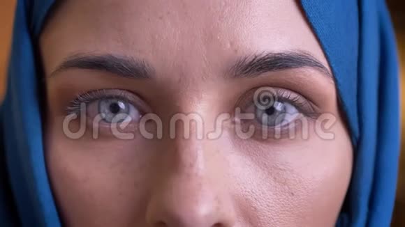 戴头巾的成年穆斯林女性特写镜头用她美丽的灰色眼睛直视镜头视频的预览图