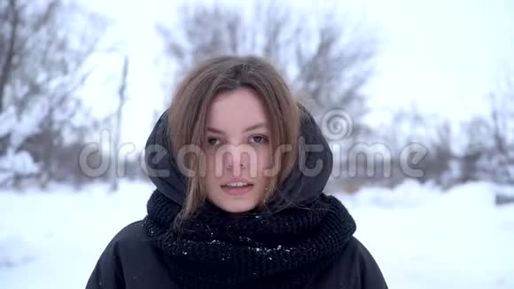 美丽的微笑的年轻女子在外面欣赏冬天穿着黑色衣服快乐的护肤概念慢动作的肖像视频的预览图